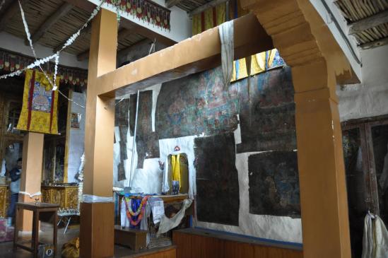 L'intérieur de la salle de prières de la gompa de Phuktal avec les thangkas collées sur le mur