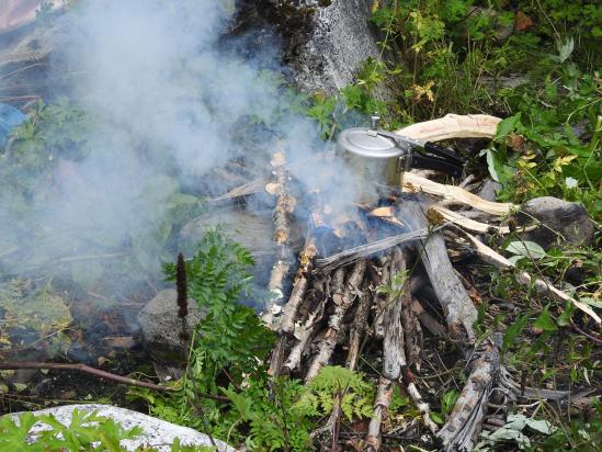 Dal bhat en préparation dans la cocotte-minute sur des branches de bouleau charriées par la rivière