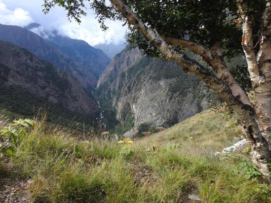 La vallée de la Takla khola vue en enfilade avec, immergés dans les nuages, les sommets du Kanjiroba