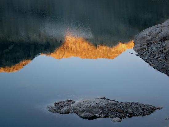 Depuis le barrage, reflet sur les eaux du lac du Portillon d'Oo des premiers rayons du soleil sur les montagnes alentours